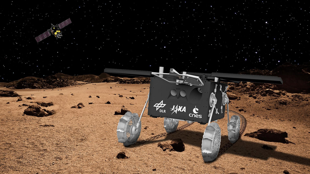 Idefix auf Krallen unterwegs 
Die MMX-Mission wird erstmals die Topografie, innere Struktur, Zusammensetzung und Schwerkraft des Marsmondes untersuchen und Bodenproben, die Idefix während seiner Tour über den Marsmond gesammelt hat, zur Erde zurückbringen - so etwa 2031. Grafik: DLR 