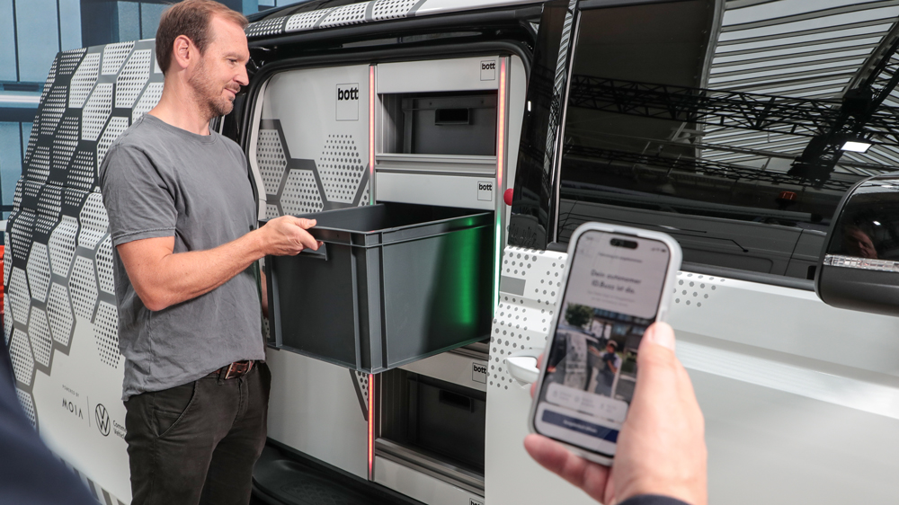 Selbst ist der Mann 
Ist der Lieferwagen angekommen, muss der Kunde seine Ware selbst am Wagen abholen - einen Fahrer gibt es nicht. Die Tür öffnet der Besteller mit einer Smartphone-App, wie Moia-Stratege Lukas Haupt demonstriert. Foto: Uli Sonntag für VWN   